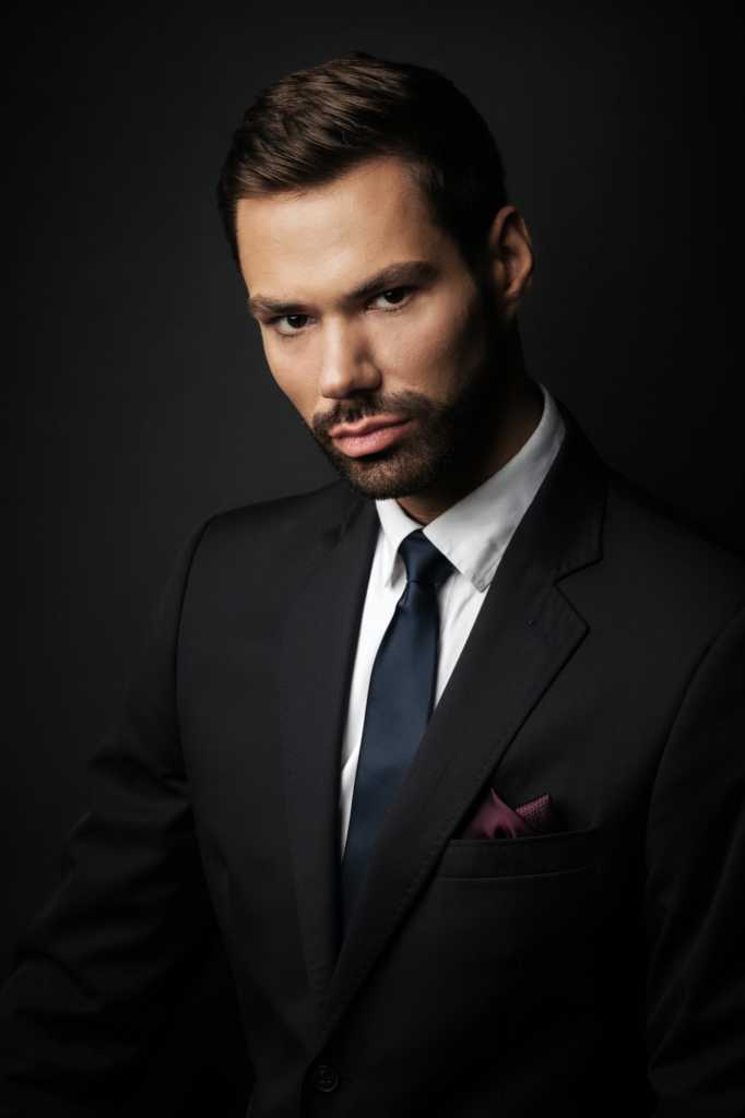 Handsome young businessman portrait on black background